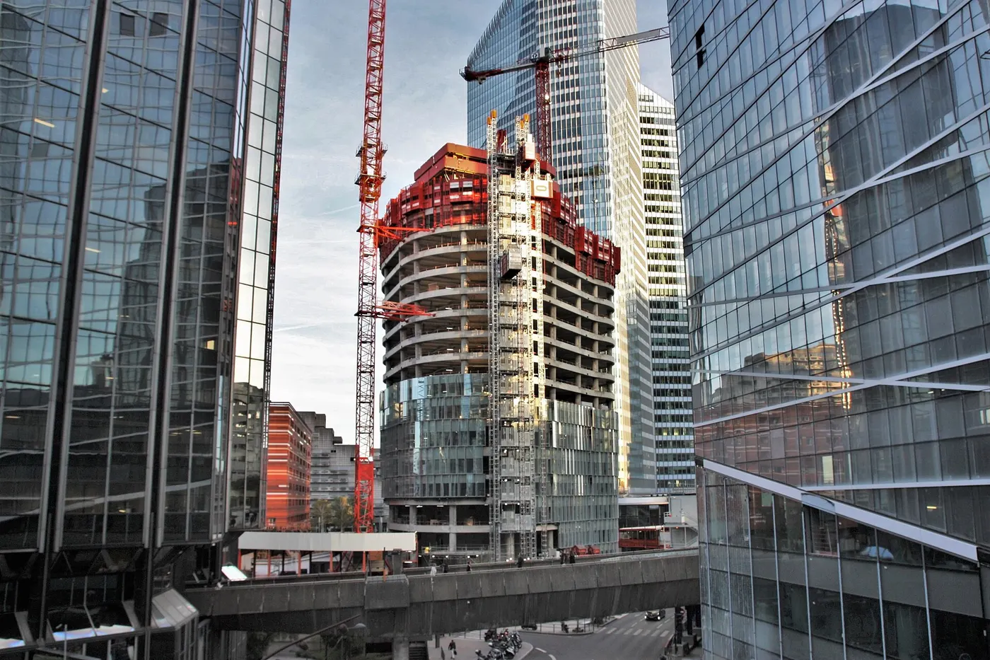 La tour Alto en construction à La Défense, avec sa structure, ses grues rouges et ses façades vitrées en cours de pose.