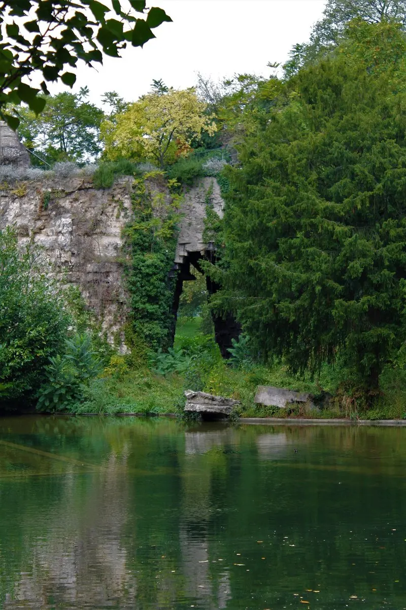 Ancienne carrière de gypse devenue falaise végétalisée au bord d'un lac.